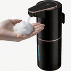 Black and rose gold soap dispenser dispensing soap into a hand against a white background