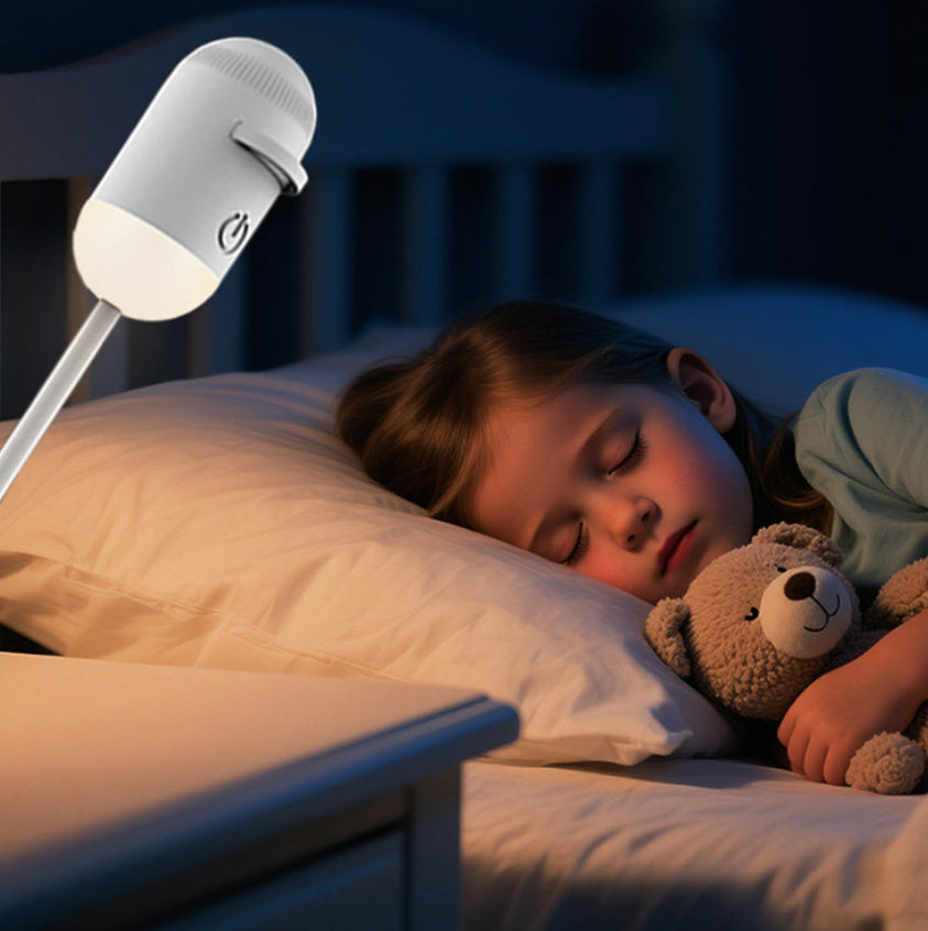 Child sleeping in bed with a night light and teddy bear