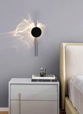 Modern wall sconce above a nightstand with a glass and tray in a bedroom setting.
