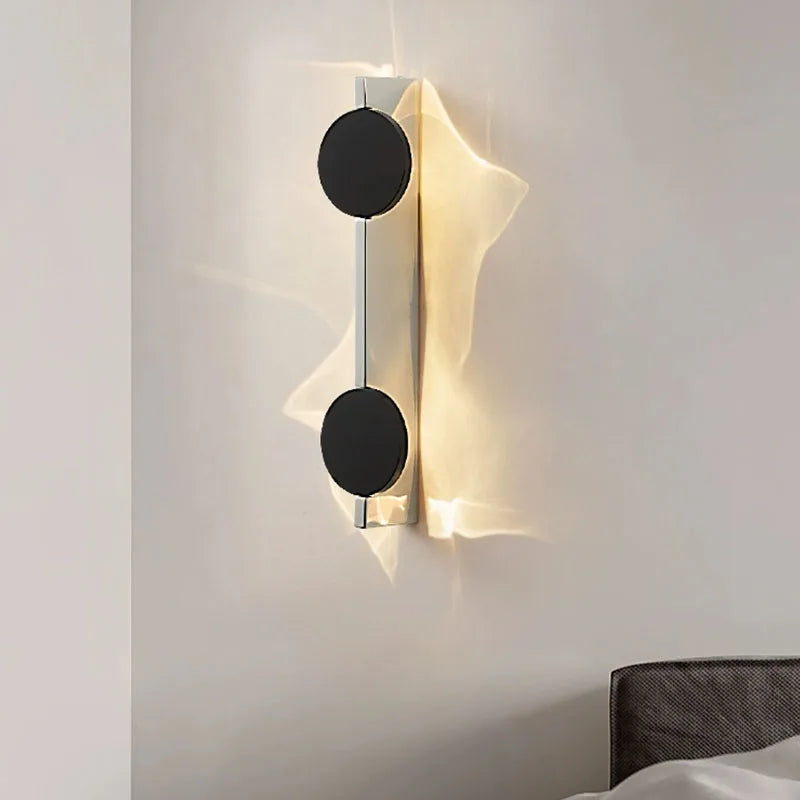 Modern wall lamp with black circular design on a white wall
